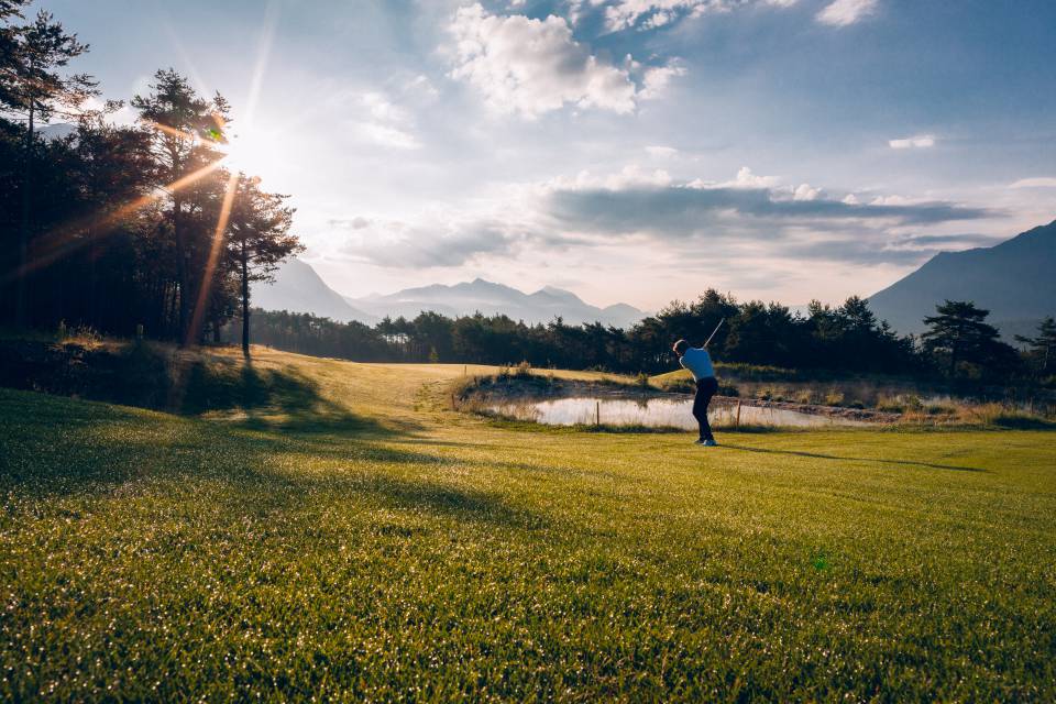 Mann beim Abschlag auf dem Golfplatz