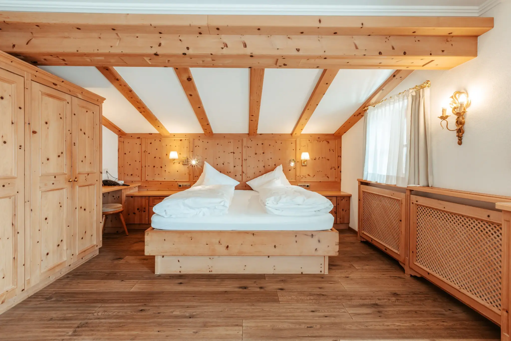 Biozimmer Zirbe mit Balkon unter Holzbalkendecke, Doppelbett und voller Zirbenholz-Ausstattung im Biohotel Schweitzer