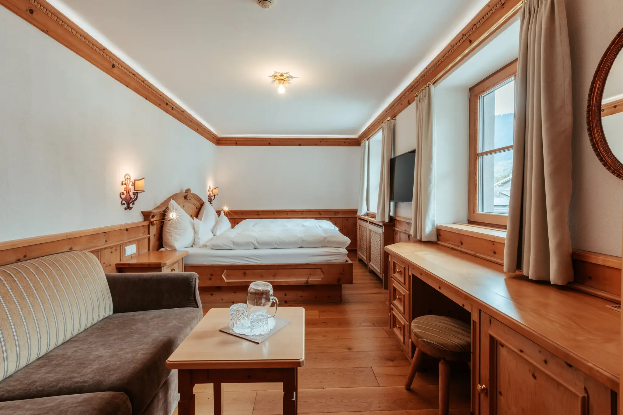Biozimmer Zirbe ohne Balkon mit Doppelbett, Sofa und Zirbenholz-Vertäfelung im Biohotel Schweitzer