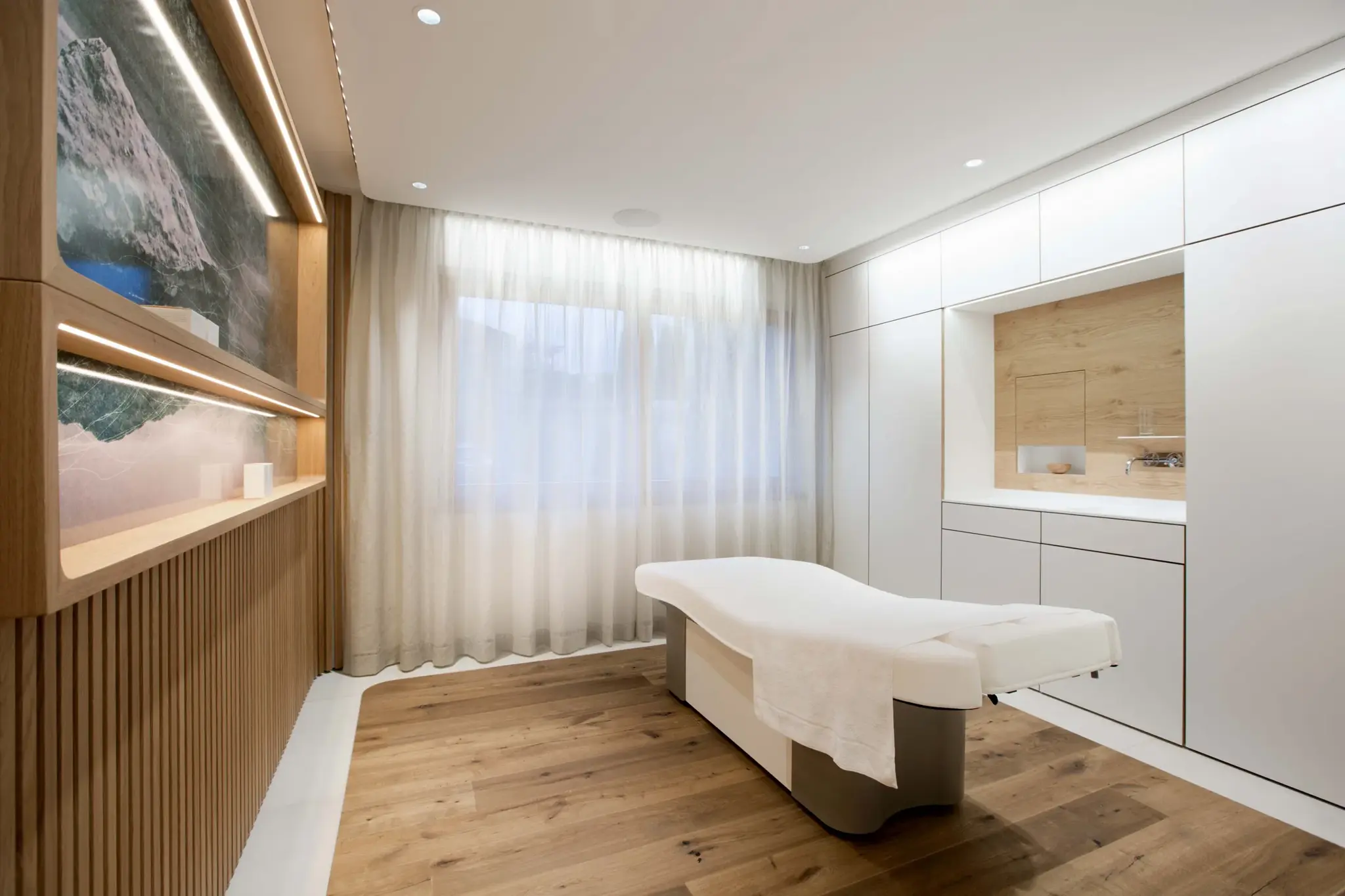 Bright treatment room with a massage table and wooden details in the Day Spa of Alpenresort Schwarz