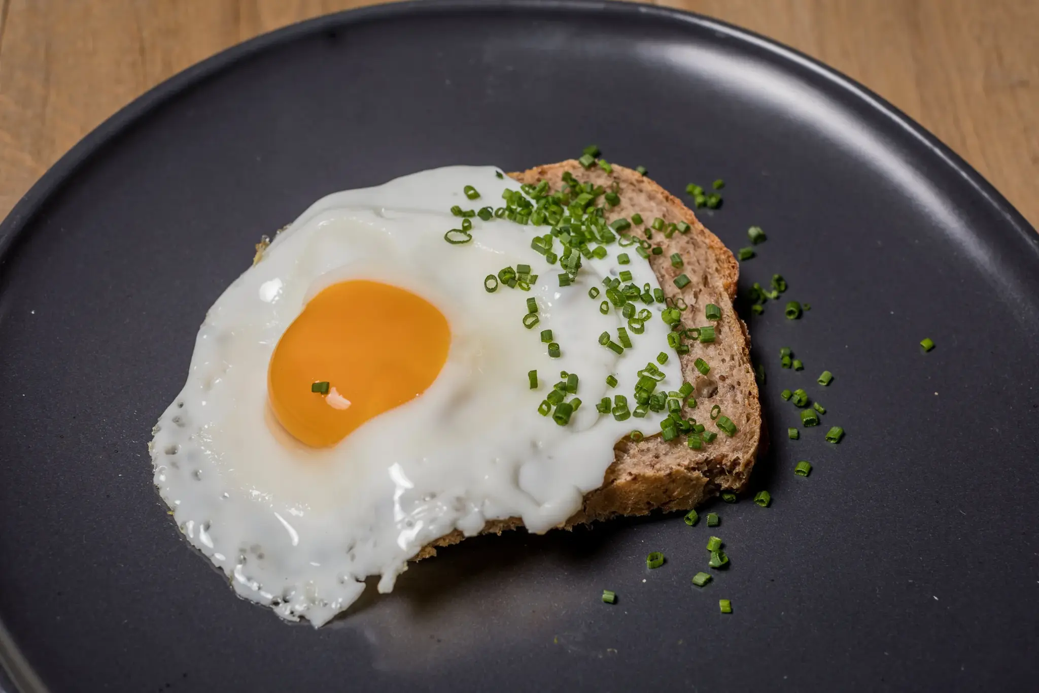 Organic fried egg on wholegrain bread with fresh chives for breakfast at Biohotel Schweitzer