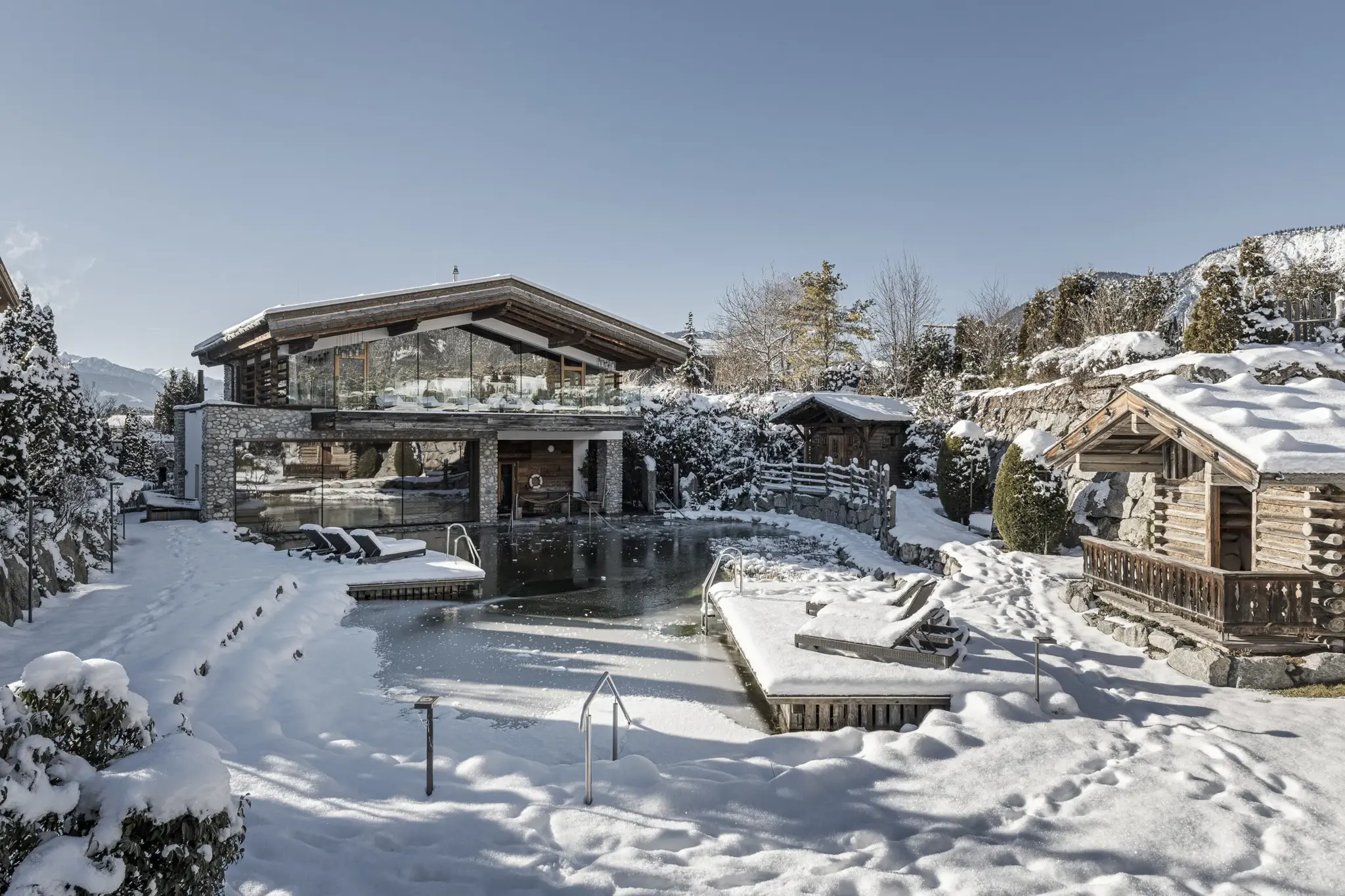 Snow-covered Day Spa with natural bathing pond, sauna huts and mountain panorama in winter — Fasting Week Plus at Alpenresort Schwarz