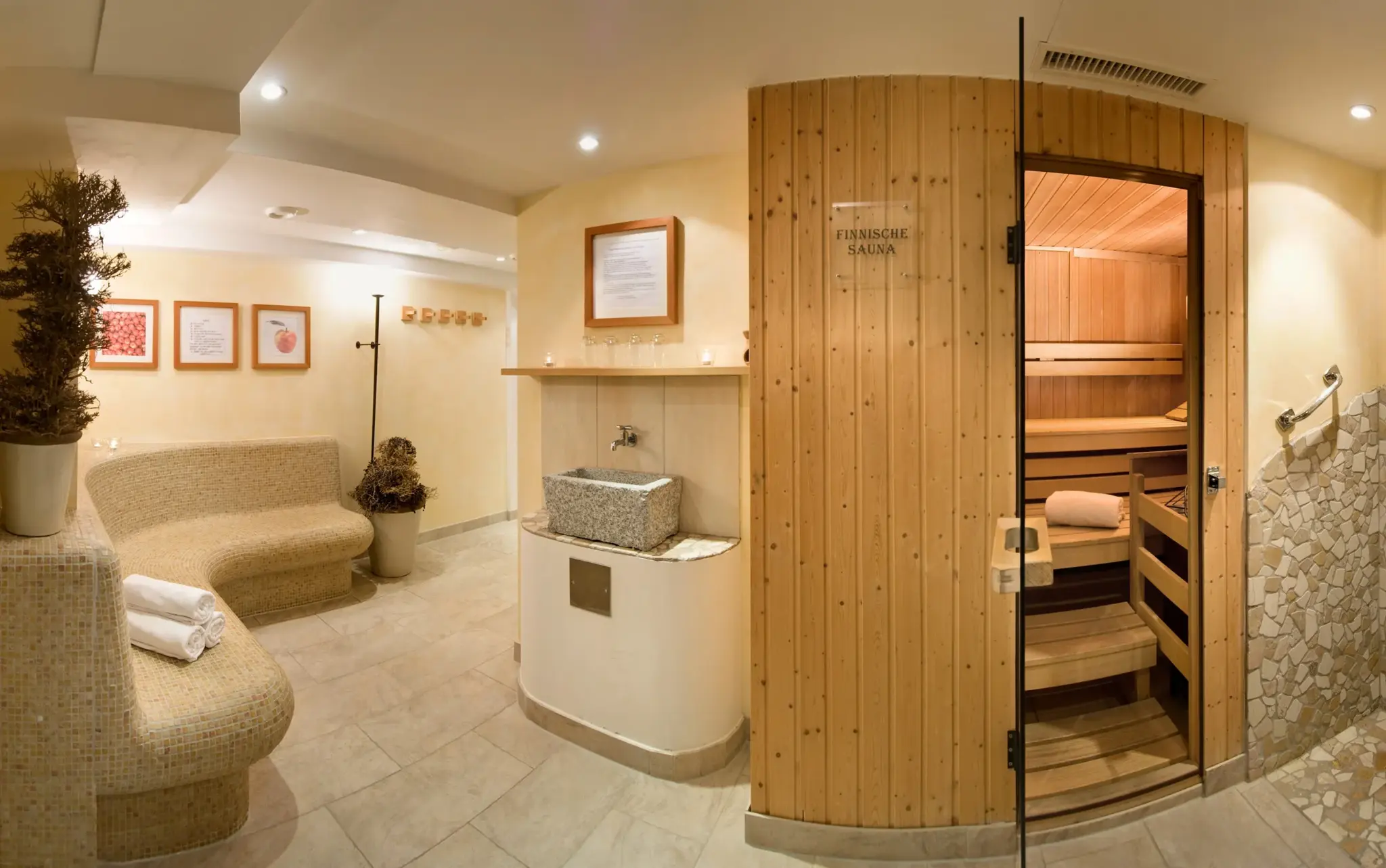 Finnish sauna of pale wood with a cosy resting bench in the sauna village at Alpenresort Schwarz