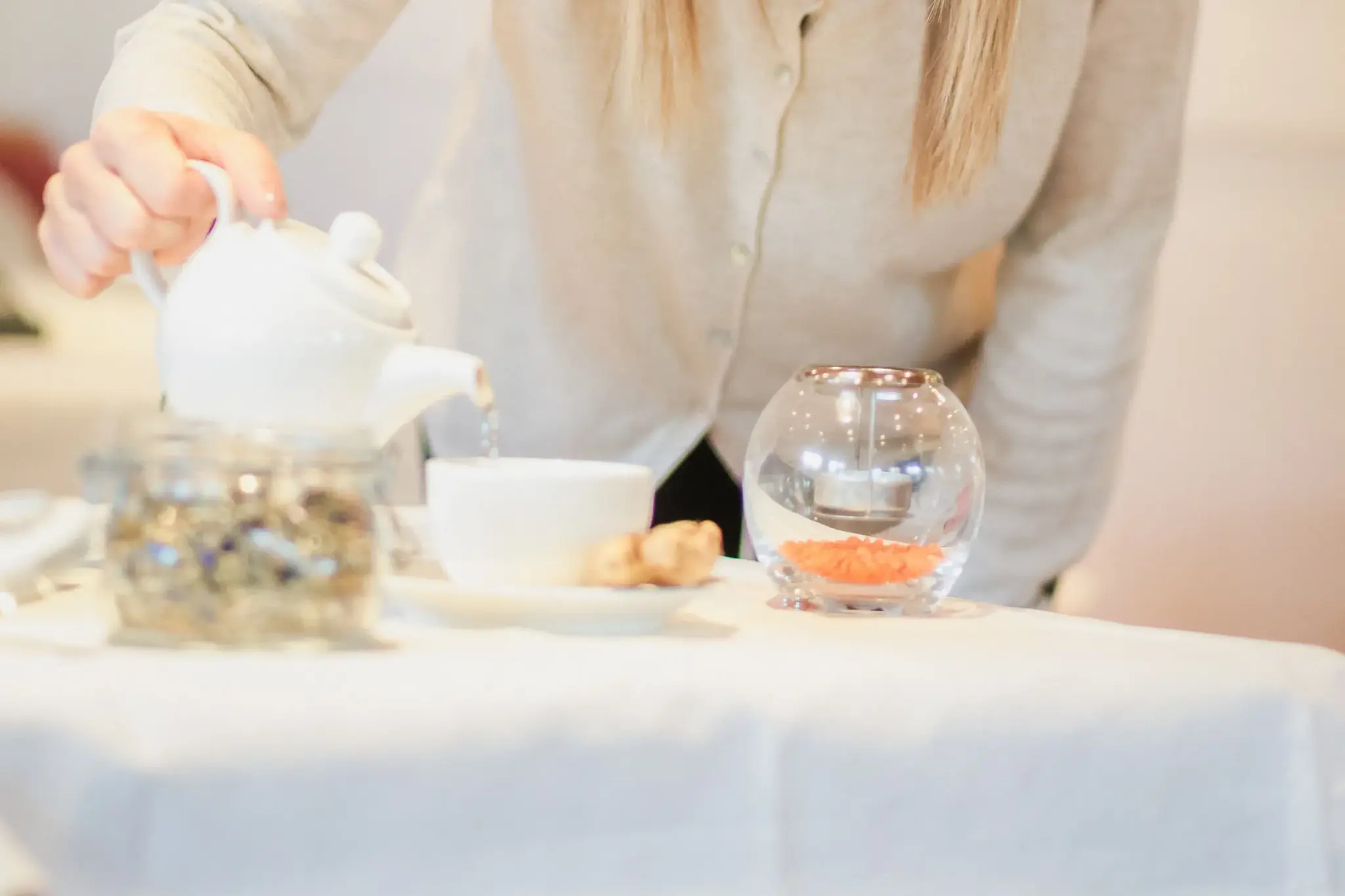 Woman pouring herbal tea from a white pot — light, alkaline support during therapeutic fasting at Biohotel Schweitzer