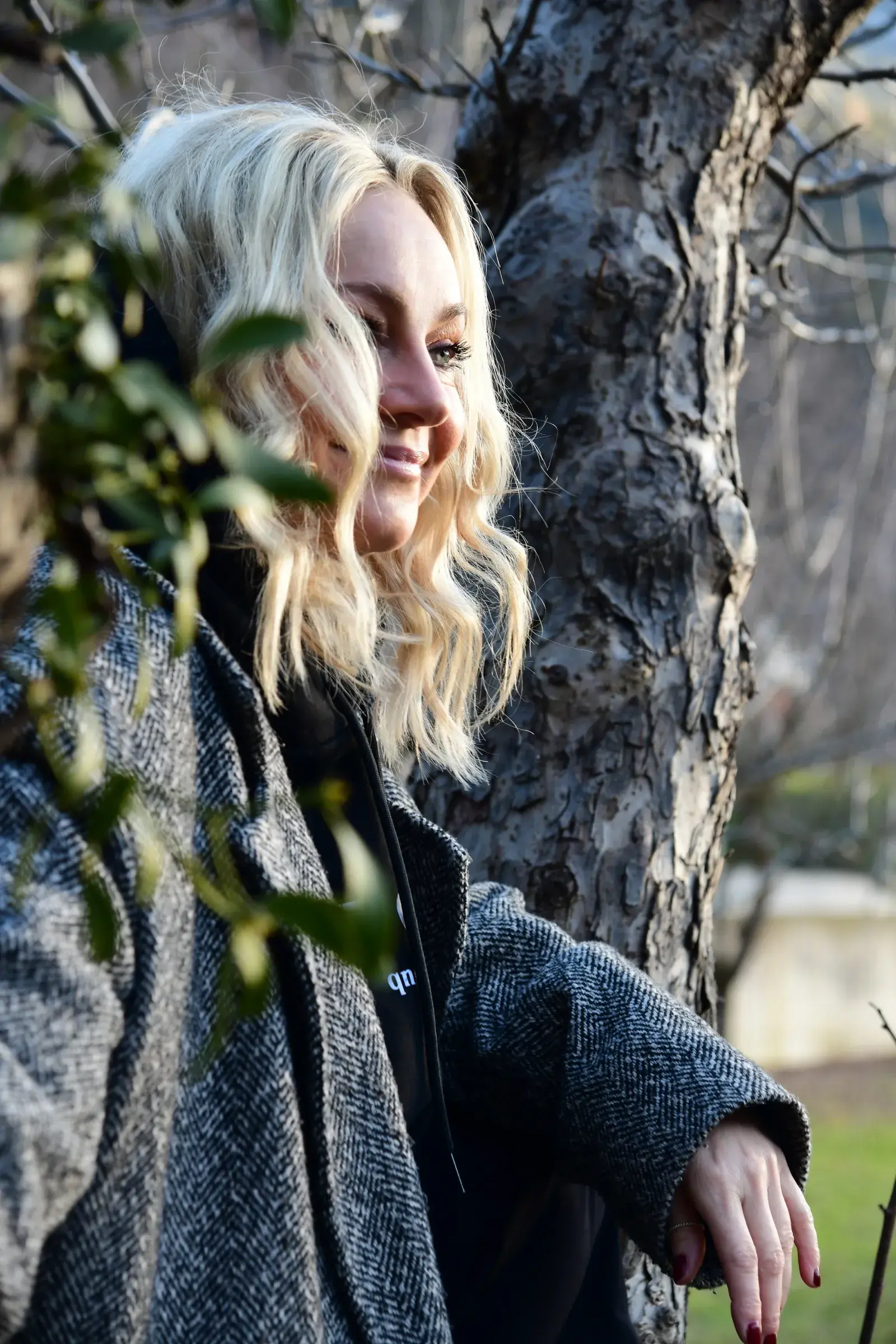 Isabel Kapeller mit blondem Haar an einem Baum, Leiterin des Schreibretreats für Frauen im Biohotel Schweitzer