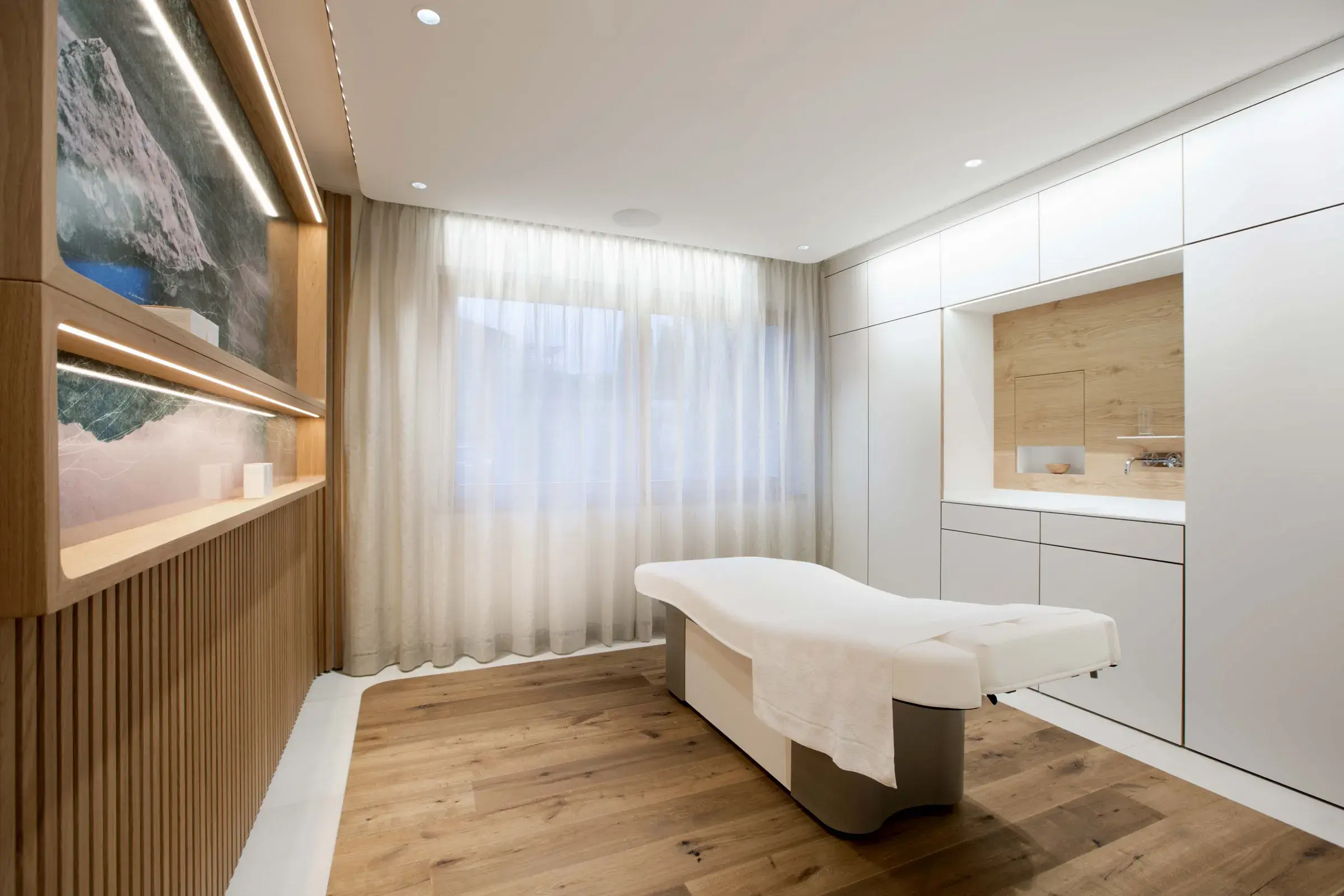 Heller Behandlungsraum mit Massageliege und Holzdetails im Day Spa des Alpenresort Schwarz